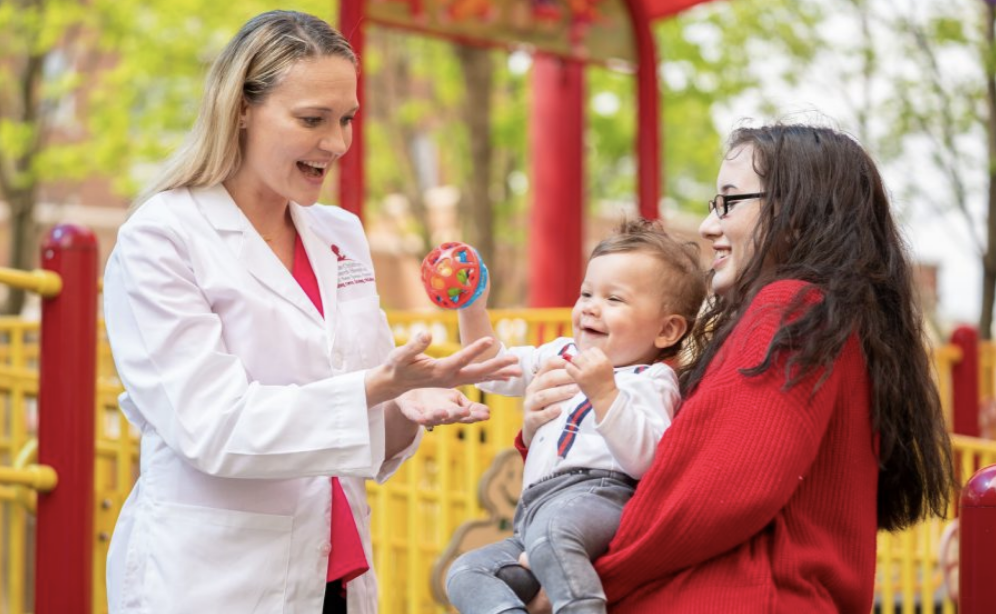 St. Jude clinician with a child and mother.